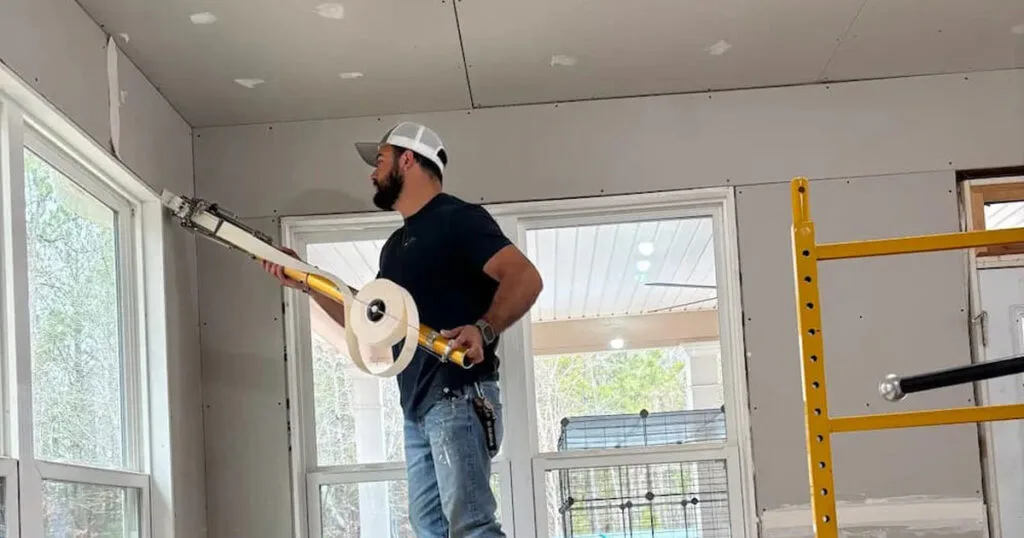 contractor using a professional automatic drywall taping tool
