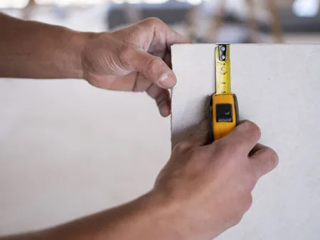 measuring the thickness of drywall with a tape measure