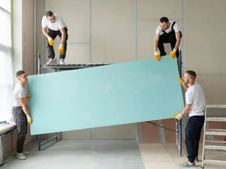 drywall contractors lifting gypsum board